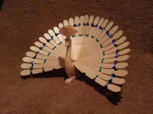 Peacock made of pine.  Approximately 14" wide. Ribbon woven through feathers.