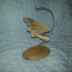 I made a stand from a piece of oak and a brass rod. It works great for displaying the birds.